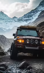 a red vehicle with its lights on and a mountain in the background