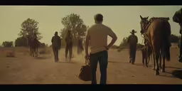 a group of men walking away from horses