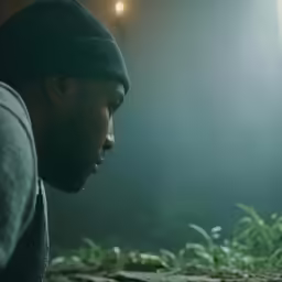 a man standing up looking down at his cell phone
