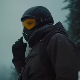 a man in black jacket and yellow helmet in winter