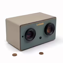an old style camera is next to some coin