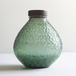 a green vase with curved patterns on it