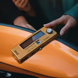 a gold colored clock mounted on the hood of a orange motorcycle