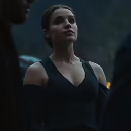 a woman in a black top looks on while she stands by