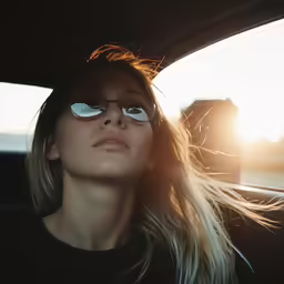 woman with her head sticking out of the window of a car looking straight ahead