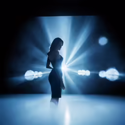 a woman wearing a dark colored evening dress stands in a dimly lit area
