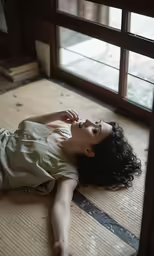 woman lying down on floor next to window