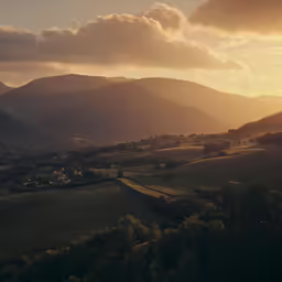 a valley and field with mountains at sunset