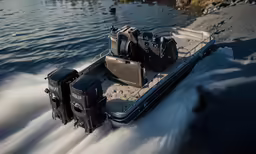 a large gray boat is speeding on the water