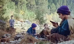 children in the woods, one holding a cellphone and another sitting