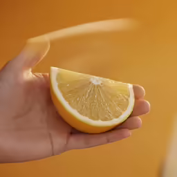 an image of someone that is holding up half of a lemon