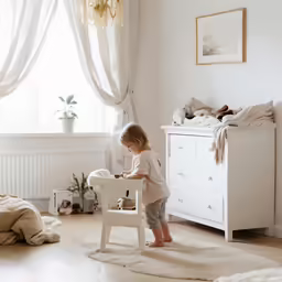 a child playing in a white chair in the living room