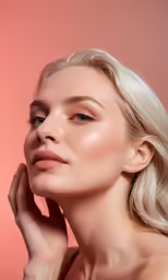 a woman with long blond hair is posing in front of a pink background