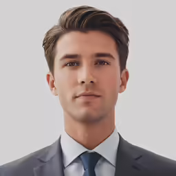 a young man in a suit and tie, looking at the camera