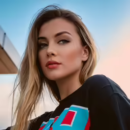 young woman in short and colorful shirt posing outdoors