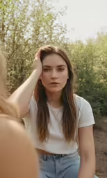 a woman is sitting down wearing a white shirt