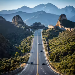a highway in the mountains with trees and bushes on either side