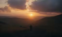 a man in the wilderness looking at the sunset