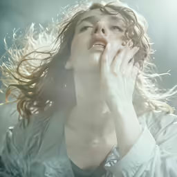 a woman in white is holding her hands to her face