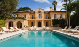 a large building with lounge chairs next to a swimming pool