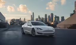 a white tesla model s is driving down the street