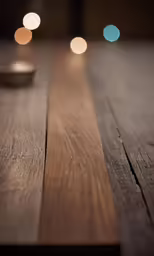a wooden table with three light colored dots placed on top of it