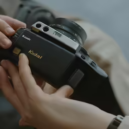 a person holding up a camera with a flash pointed on it
