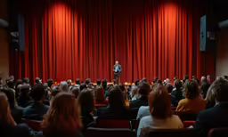 a crowd of people watching a presentation on stage