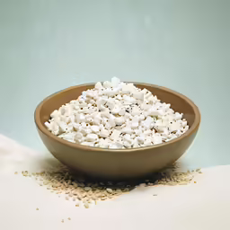 a brown bowl filled with white pieces of marsh