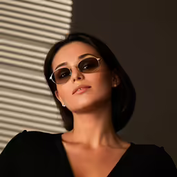 a woman in brown and black wearing round glasses