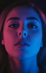 a woman in pink, blue and purple lighting posing