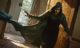a woman in a hoodie dancing with her arm up