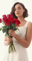 a woman holding some very pretty red roses