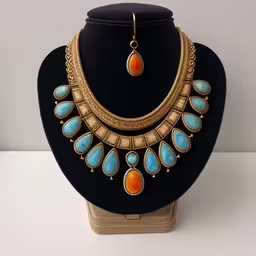 a necklace and earrings sitting on top of a black mannequin,a display of necklaces on a stand,a black necklace on a mannequin with multiple gems,the necklace is adorned with turquoise and orange stones,jewelry set on display in front of white wall
