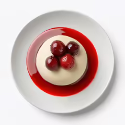 a plate with two berries and cream in it