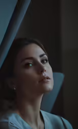 woman looking up with a side view of face looking out the window