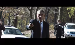 a man in a suit and tie pointing