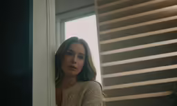 a close up of a person standing near a window