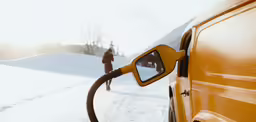 someone is walking beside of a car on the snowy road