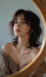 the woman in the photo is looking out from behind a mirror