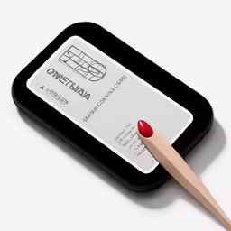 an object with red nail polish and a wooden stick