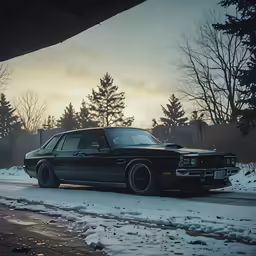 a black car parked on the side of the road in the snow