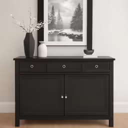 a black and white vase is next to a small cabinet