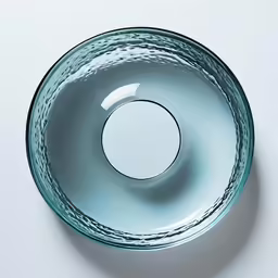 an overhead shot of a blue glass bowl on a white surface