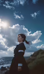 a woman in black standing on rocky beach