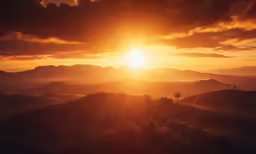 a sunset in the mountains above some hills