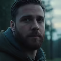 man with long beard wearing winter coat outside