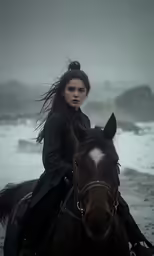 a woman riding a horse along a beach