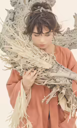 a young girl holding dried plants with her hand
