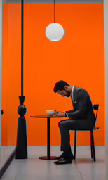 a man is writing in front of an orange background